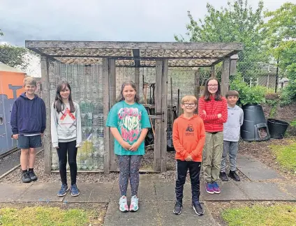  ?? ?? Eco warriors Children at Burrelton Primary School have started a campaign involving the two Scotmid stores in Coupar Angus to collect used two-litre water bottles for the project