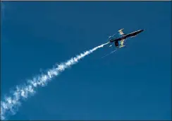  ?? Jenny Sparks / Loveland Reporter-herald ?? A U.S. Navy Blue Angels F-18 Super Hornet turns almost upside-down as the pilots perform a carrier break, a normal part of their landing routine, Tuesday before landing at the Northern Colorado Regional Airport in Loveland.