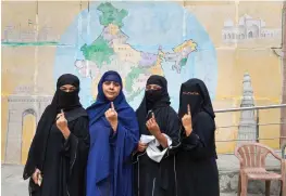  ?? — PTI ?? Voters show their ink-marked fingers after casting vote for the MCD elections at a polling station in East Delhi on Sunday.