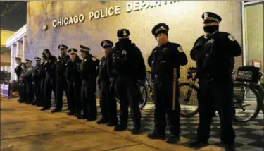  ?? PAUL BEATY — THE ASSOCIATED PRESS ?? Police officers line up outside the District 1 central headquarte­rs at 17th and State streets in Chicago, during a protest for 17-year-old Laquan McDonald, who was fatally shot in October 2014. Chicago Police Officer Jason Van Dyke was charged with first-degree murder in the killing.