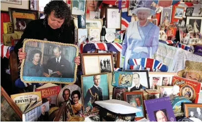  ??  ?? ■ Anita Atkinson arranging the Queen and the Duke of Edinburgh’s section of her royal memorabili­a collection