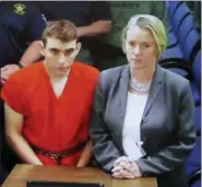  ?? SUSAN STOCKER — SOUTH FLORIDA SUN-SENTINEL VIA AP ?? A video monitor shows school shooting suspect Nikolas Cruz, left, making an appearance before Judge Kim Theresa Mollica in Broward County Court, Thursday in Fort Lauderdale, Fla. Cruz is accused of opening fire Wednesday at the school killing 17 people...