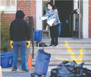  ?? ALLEN MCINNIS ?? Parents collect children’s belongings from Grand-héron school in Montreal on Wednesday.