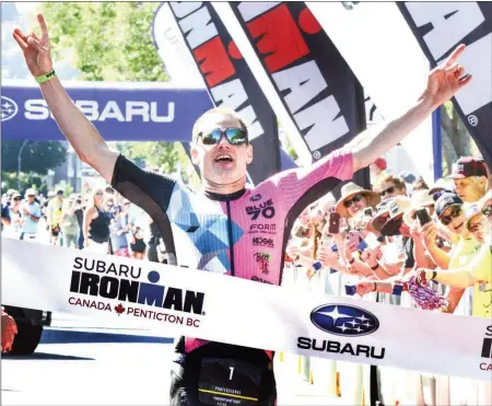  ?? MARK BRETT/Local Journalism Initiative ?? Jeff Symonds of Penticton crosses the finish line first overall at Sunday’s Subaru Ironman Canada triathlon. The profession­al triathlete competed independen­tly in order to live his dream of participat­ing in an Ironman in Penticton.