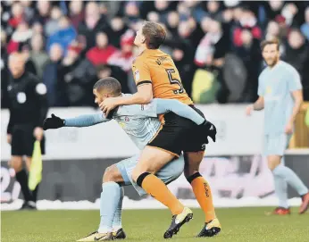  ??  ?? Lewis Grabban fails to shake off the close attention of a Wolves player.