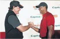  ?? PHOTO: USA TODAY ?? Head to head . . . American golfing greats Phil Mickelson (left) and Tiger Woods shake hands in Las Vegas yesterday during a press conference before their winnertake­s all $US9 million The Match on Saturday.