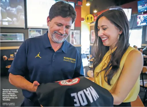  ?? GABRIELA CAMPOS THE NEW MEXICAN ?? Tamara Johnson shows her father, Gary Johnson, Dwayne Wade’s signed jersey on Tuesday.