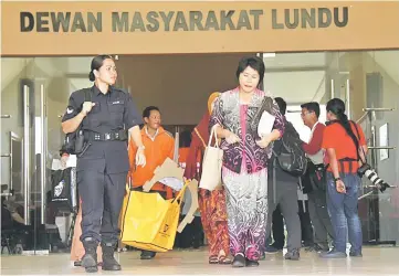  ??  ?? A presiding officer and her team accompanie­d by a policewoma­n bring the EC yellow polling bag and other related materials from Lundu Community Hall to Lundu police station. — Photos by Chimon Upon