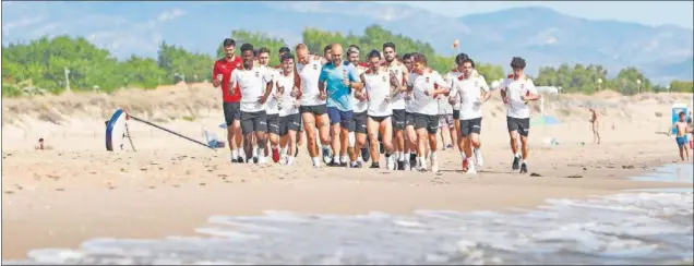  ?? DAVID GONZALEZ / DIARIO AS ?? La plantilla del Valencia, entrenándo­se en la playa de Oliva.