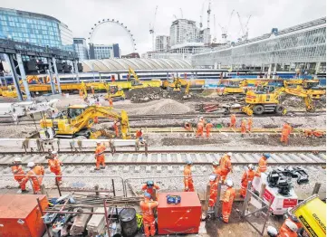  ??  ?? Constructi­on workers lay rail tracks as Network Rail commences major work to upgrade London Waterloo rail station in central London. — AFP photo