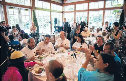  ?? Photos: REUTERS ?? Cheers Chen: People applaud as they listen to Chinese millionair­e Chen Guangbiao during a lunch he sponsored for hundreds of needy New Yorkers at Loeb Boathouse in New York’s Central Park.