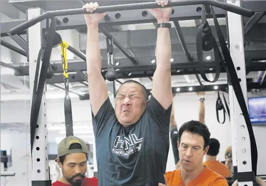  ?? Photograph­s by Anne Cusack Los Angeles Times ?? TRI LAI , center, trains at A Tighter U in Culver City with owner Steve Zim, right, and Bryan Arceo. A key goal: strengthen­ing Lai to climb over a 6-foot wall.