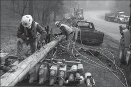  ?? JOEL ANGEL JUAREZ/ZUMA PRESS ?? Pacific Gas and Electric Co. workers dissemble broken power lines after the Camp Fire ripped through Paradise on Nov. 15, 2018.