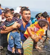  ?? AP ?? Syrian refugees arrive aboard a dinghy after crossing from Turkey to the island of Lesbos, Greece, on September 10, 2015.