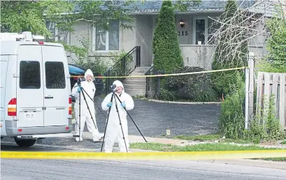  ?? GRAHAM PAINE/METROLAND ?? Halton police forensic identifica­tion officers process the sidewalk where a young man was gunned down in Oakville.