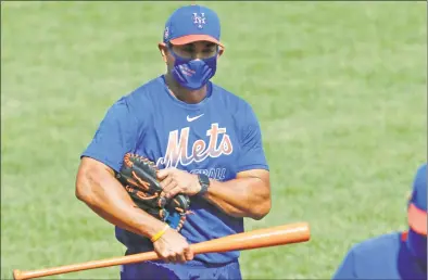  ?? Kathy Willens / Associated Press ?? New York Mets manager Luis Rojas holds a bat as he walks off the field following a workout at Citi Field.