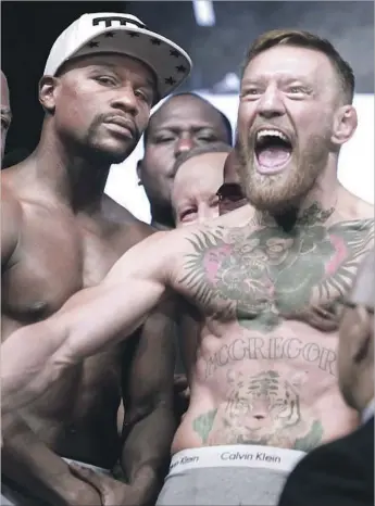  ?? John Gurzinski AFP/Getty Images ?? FLOYD MAYWEATHER JR. and Conor McGregor pose during their Las Vegas weigh-in. Now that the hype is over, the question is whether a novice boxer stands a chance against an all-time great.