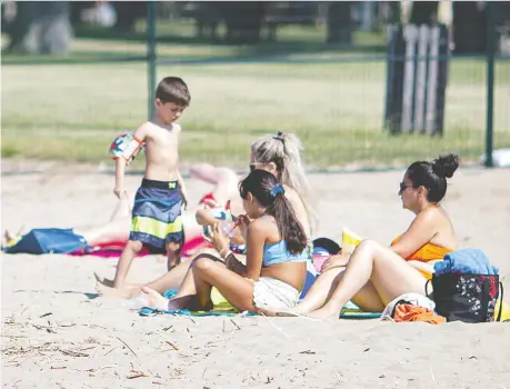  ?? DAX MELMER ?? People try to beat the heat while at a fenced-off Sand Point Beach in Windsor on Friday, when temperatur­es reached a high of 33 C.