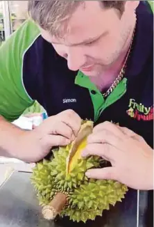  ?? PIC TAKEN FROM FACEBOOK ?? Simon opening a durian.