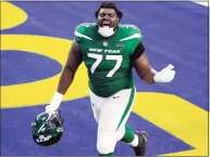  ?? Ashley Landis / Associated Press ?? Jets offensive tackle Mekhi Becton celebrates as he runs off the field after a win over the Rams earlier this season.