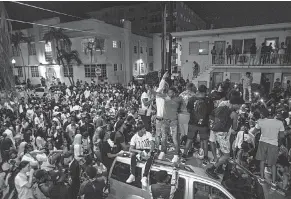  ?? DANIEL A. VARELA/ AP ?? Crowds defiantly gather in the street an hour past curfew in Miami Beach, Fla., on March 21, 2021.