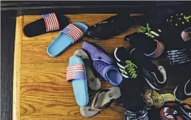  ??  ?? Learning from home has its advantages as Sifa Eca's children's shoes are piled up outside the front door of their home in Albany.