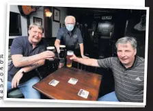  ??  ?? Chin chin Post columnist Bob Shields serves the cold stuff to Michael Hamilton, left, and Gordon Rodie at his Twa Dugs boozer