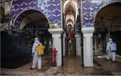  ??  ?? Municipal workers disinfect the market ahead of its big reopening. This has been the longest closure in the bazaar’s more than 550-year-old history, except for forced shutdowns following fires and earthquake­s