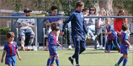  ??  ?? Lionel Messi and Luis Suarez watch on quietly as their sons play for Barcelona’s youth team