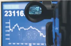  ??  ?? An electronic display chart showing the afternoon trading trend of the blue chip Hang Seng Index is seen through a camera at a brokerage in Hong Kong. Hong Kong police are struggling to deal with digital pump-and-dump schemes targeting brokerages – a...