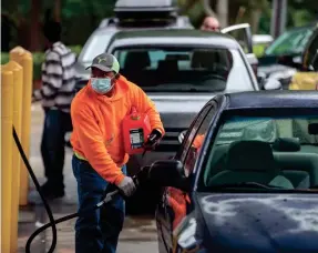  ?? ROBERT WILLETT/AP ?? Customers fill up their automobile­s and gas containers Wednesday at a Circle K in Raleigh, N.C. Fuel experts say there’s no reason to panic.