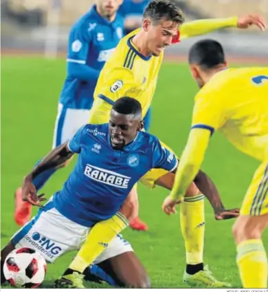  ?? MIGUEL ÁNGEL GONZÁLEZ ?? Jojo, que fue titular, intenta llevarse el balón desde el suelo entre dos jugadores del Cádiz B.