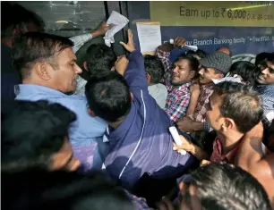  ?? AP ?? People jostle to get inside a bank to exchange discontinu­ed currency notes in New Delhi. —