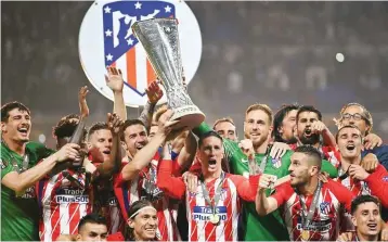  ??  ?? Atletico Madrid players celebrate with the Europa League title on Wednesday