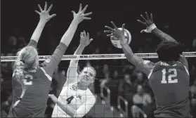  ?? JOSHUA A. BICKEL/TRIBUNE NEWS SERVICE ?? Minnesota'ss Paige Tapp (4) attempts a kill as Stanford's Kathryn Plummer (2) and Inky Ajanaku (12) look to block during the NCAA semifinal in Columbus, Ohio, on Thursday.