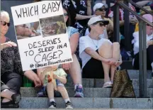  ?? The Associated Press ?? Christophe­r Baker, 3, holds a sign as he attends a Poor People’s Campaign rally with his mother, Katie Baker, behind sign, Monday in Olympia, Wash.