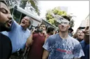  ?? MICHAEL DWYER — THE ASSOCIATED PRESS ?? A man wearing a T-shirt bearing the name of President Donald Trump, right, is hit by a flying plastic bottle of water near a “Free Speech” rally staged by conservati­ve activists, Saturday in Boston.