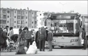  ?? AP/HASSAN AMMAR ?? Syrian families that were displaced from east Aleppo last month wait for a security check to be able to return to their homes in the Hanano district of the city Sunday.