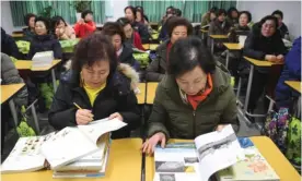  ??  ?? This picture taken on March 2, 2017 shows South Korean women, who are students aged 60 and up, looking at text books at a class room after their entrance ceremony for Ilsung Women’s School.