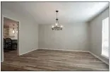  ??  ?? A modern chandelier anchors the dining room which has vinyl plank floors.