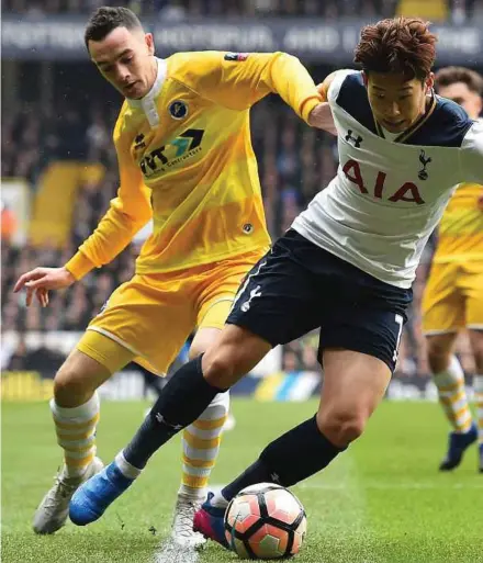  ?? AFP PIC ?? Millwall’s Shaun Williams (left) and Tottenham Hotspur’s Son Heung-Min tussle for the ball at White Hart Lane on Sunday. Tottenham won 6-0.