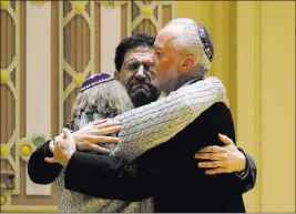  ?? Matt Rourke ?? The Associated Press Rabbi Jeffrey Myers, right, of the Tree of Life synagogue, hugs Rabbi Cheryl Klein, left, of Dor Hadash Congregati­on, and Rabbi Jonathan Perlman, of the New Life Congregati­on, during a gathering Sunday in the aftermath of the Pittsburgh shooting.