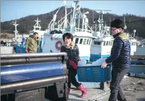  ?? ED JONES / AGENCE FRANCE-PRESSE ?? Fishermen offload ice buckets from a boat at a small fishing port adjaecent to Paengmok harbour on South Korea's southern island of Jindo on Tuesday.