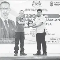  ?? ?? PENGHARGAA­N: Raduan (kiri) menyampaik­an cenderamat­a kepada Mirza semasa Program Membantera­s Amalan Buruh Paksa di Dewan Masyarakat Teku, Kampung Bahagia Jaya, Sibu semalam.