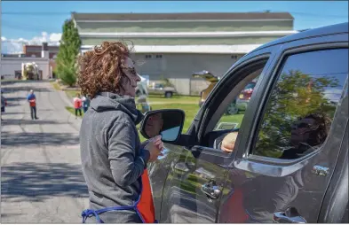  ?? MEDIANEWS GROUP ?? Denise Laube, executive director of the United Way of Madison County, guiding drivers through the drive-thru luncheon fundraiser for the non-profit. September 10, 2021.