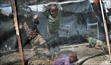  ??  ?? In this May, 2 file photo, children play inside the Moria refugee northeaste­rn Aegean island of Lesbos, Greece. AP Photo/PetroS GIAnnAkour­IS