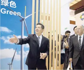 ?? AP ?? California Governor Jerry Brown (right) is shown an exhibition at an internatio­nal clean energy conference in Beijing, China on Wednesday, June 7. With President Donald Trump pulling the US out of the Paris climate accord, China and California signed...