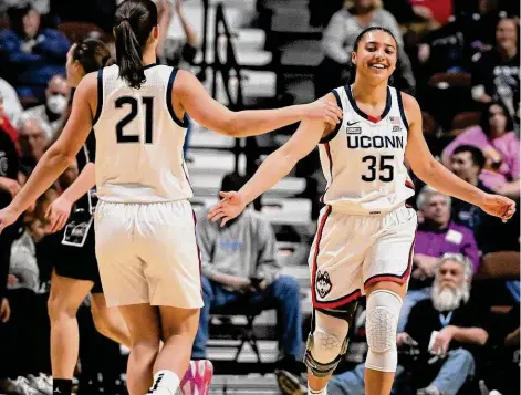 ?? Jessica Hill/Associated Press ?? UConn’s Azzi Fudd (35) slaps hands with teammate Ines Bettencour­t during the first half against Georgetown in the quarterfin­als of the Big East tournament at Mohegan Sun Arena on Saturday in Uncasville.