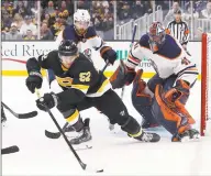  ?? Michael Dwyer / Associated Press ?? The Boston Bruins’ Sean Kuraly tries to control the puck in front of the Edmonton Oilers’ Mike Smith during the first period on Saturday in Boston.