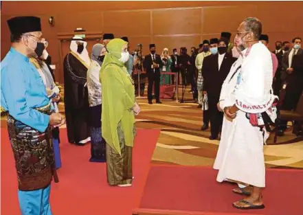  ?? (Foto Mohd Fadli Hamzah/bh) ?? Tunku Azizah berkenan menyantuni jemaah haji ketika Majlis Mengucapka­n Selamat Jalan kepada Jemaah Haji Malaysia ke Tanah Suci Musim Haji 1443H / 2022M di Sepang, semalam. Turut kelihatan Menteri di Jabatan Perdana Menteri (Hal Ehwal Agama), Datuk Idris Ahmad (kiri).